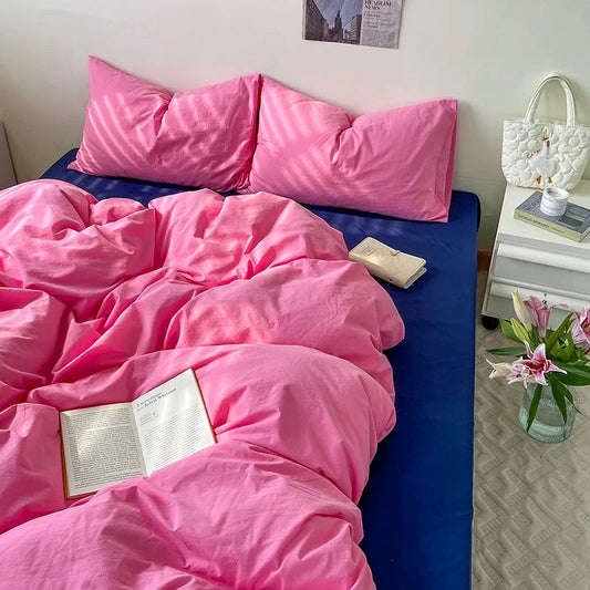 Bed having a Pink and Blue Bedding set installed on it next to decorational elements