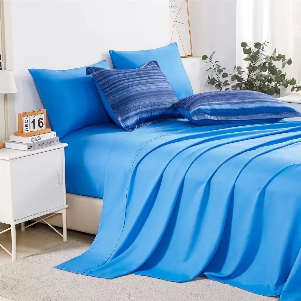 Bed covered with a blue comforter and blue striped pillows